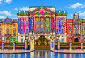 Royal Gate of the Rainbow Palace — a neoclassical palace with a facade of rainbow stripes and mosaic patterns behind a wrought-iron gate