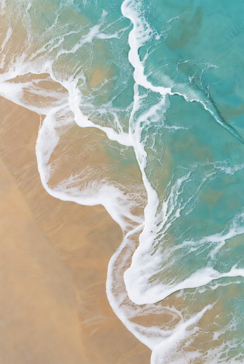 Ethereal Shore – aerial view of turquoise ocean waves meeting golden sandy shore with delicate white foam patterns