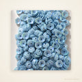 Blue iridescent 5 mm flower-shaped sequins on an ivory background