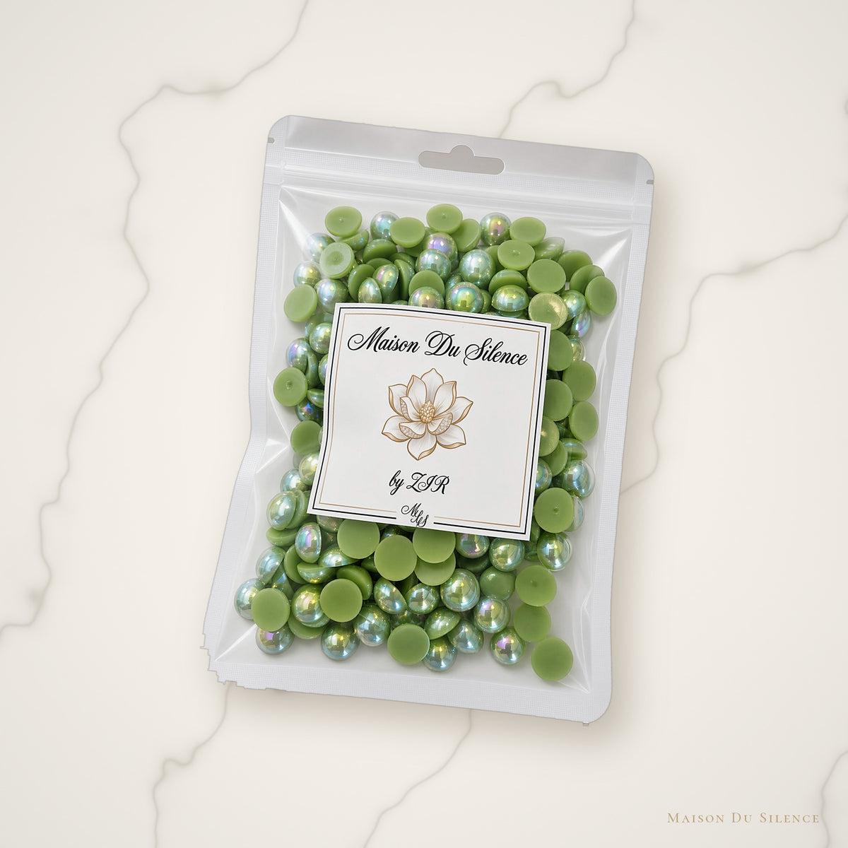 Green AB flatback pearls styled on an ivory marble backdrop