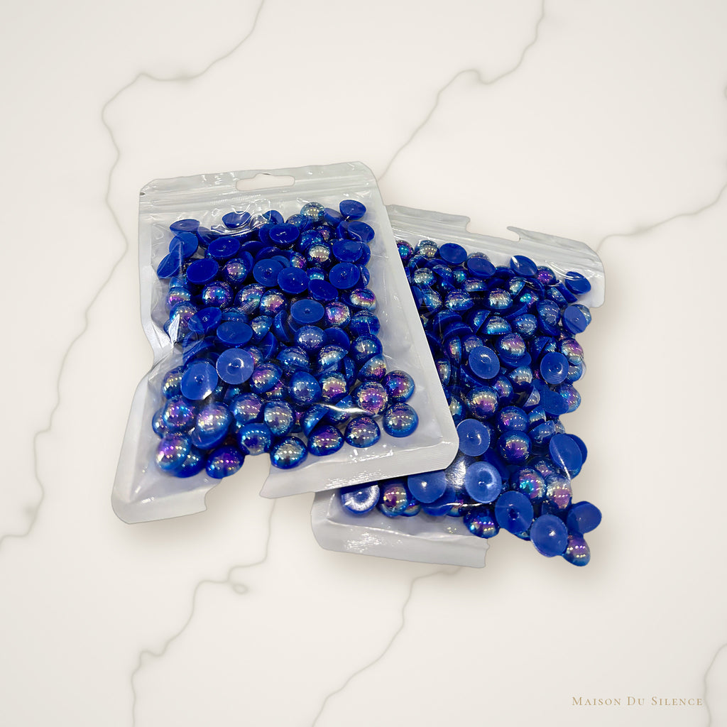 Sapphire half pearls styled on an ivory marble backdrop