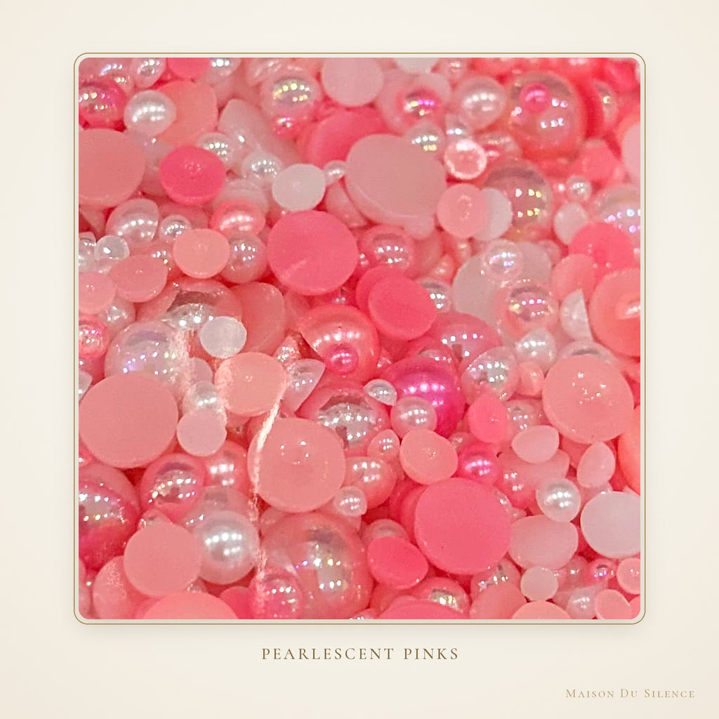 Close-up of pink pearlescent half pearls in mixed sizes