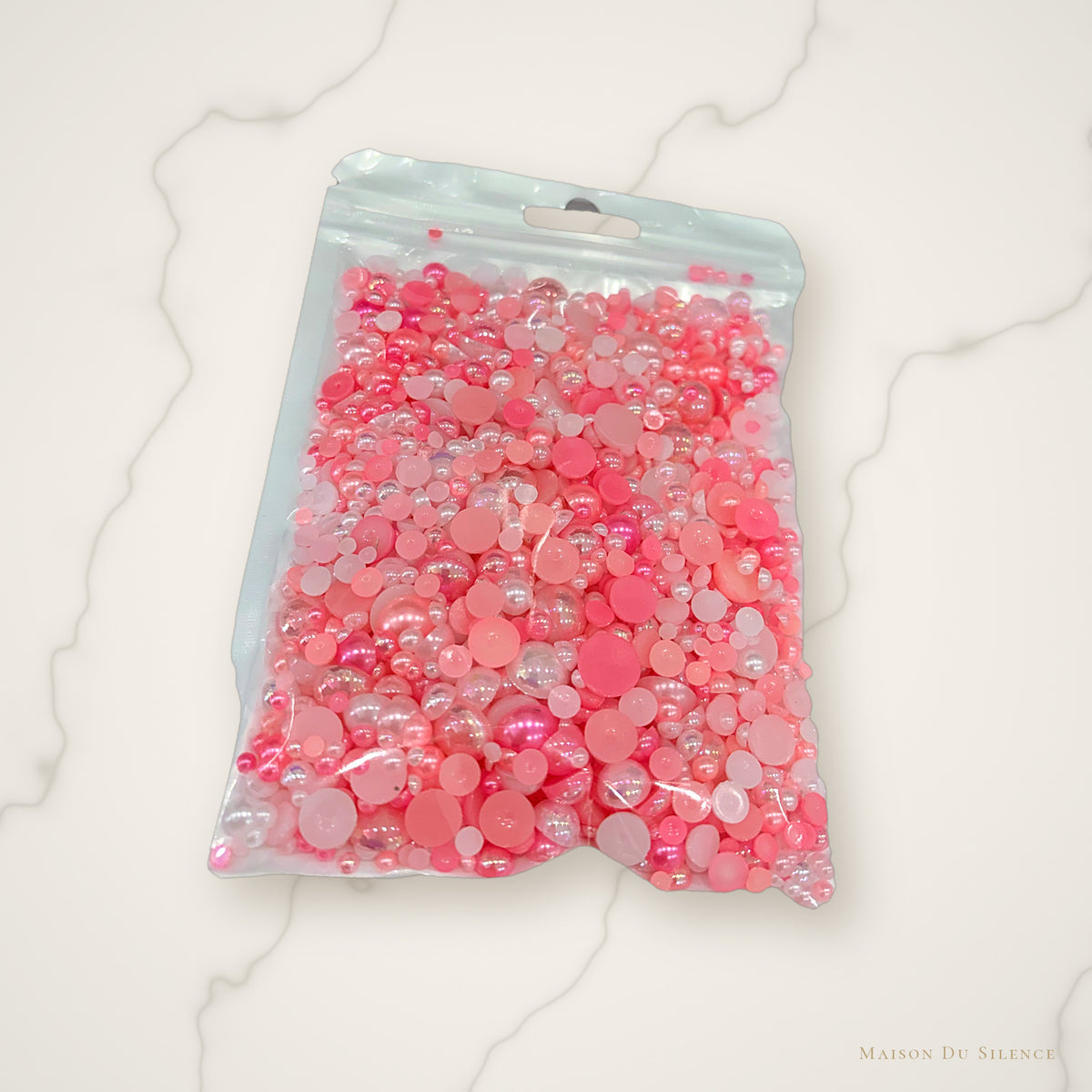 Pink half pearl mix styled on an ivory marble backdrop