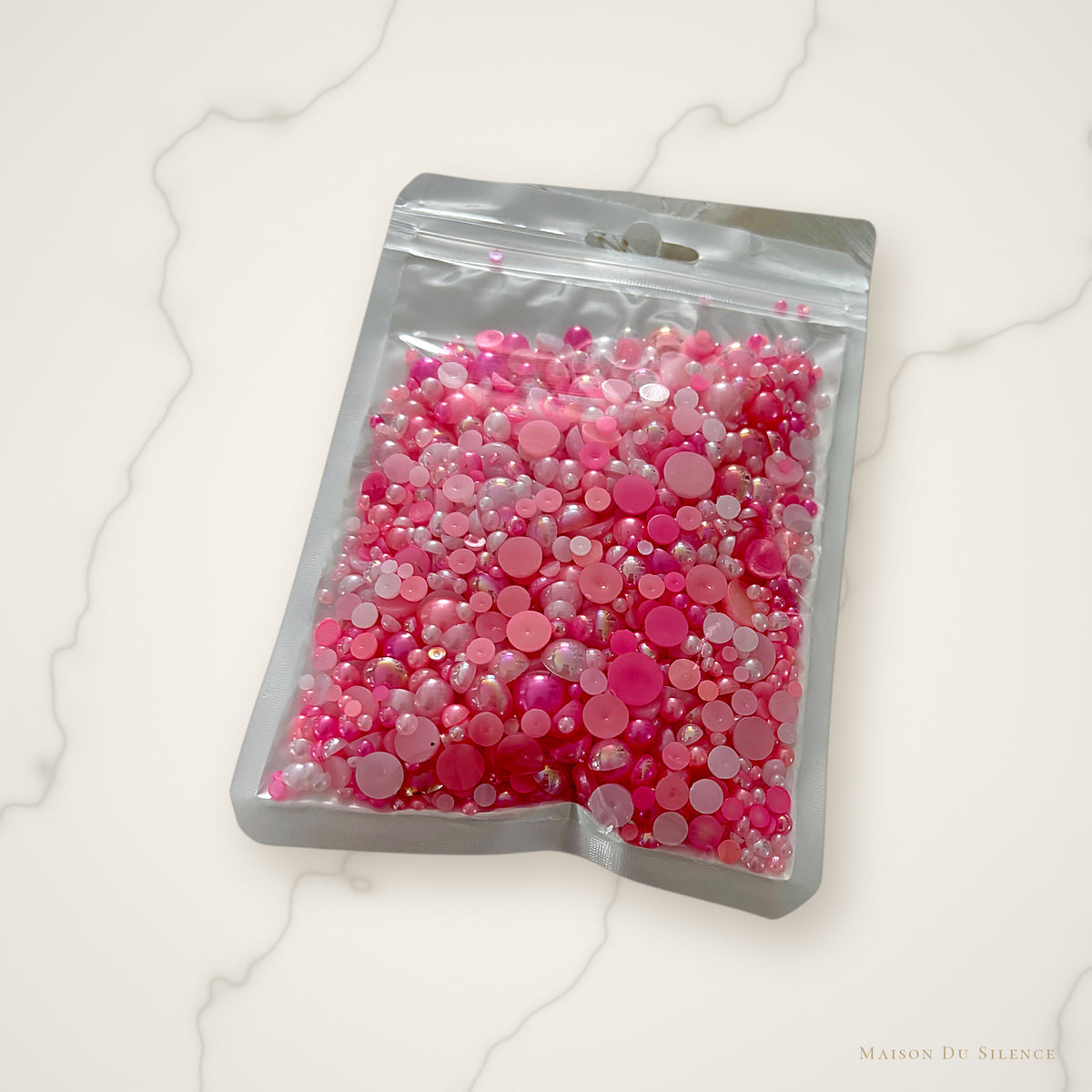 Pink half pearls styled on an ivory marble backdrop