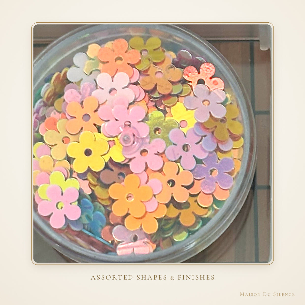 Close-up of assorted flower and round sequins in the kit compartments
