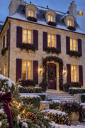 Amethyst Mansion — stone mansion with amethyst door and shutters, warm lit windows and snow at winter dusk